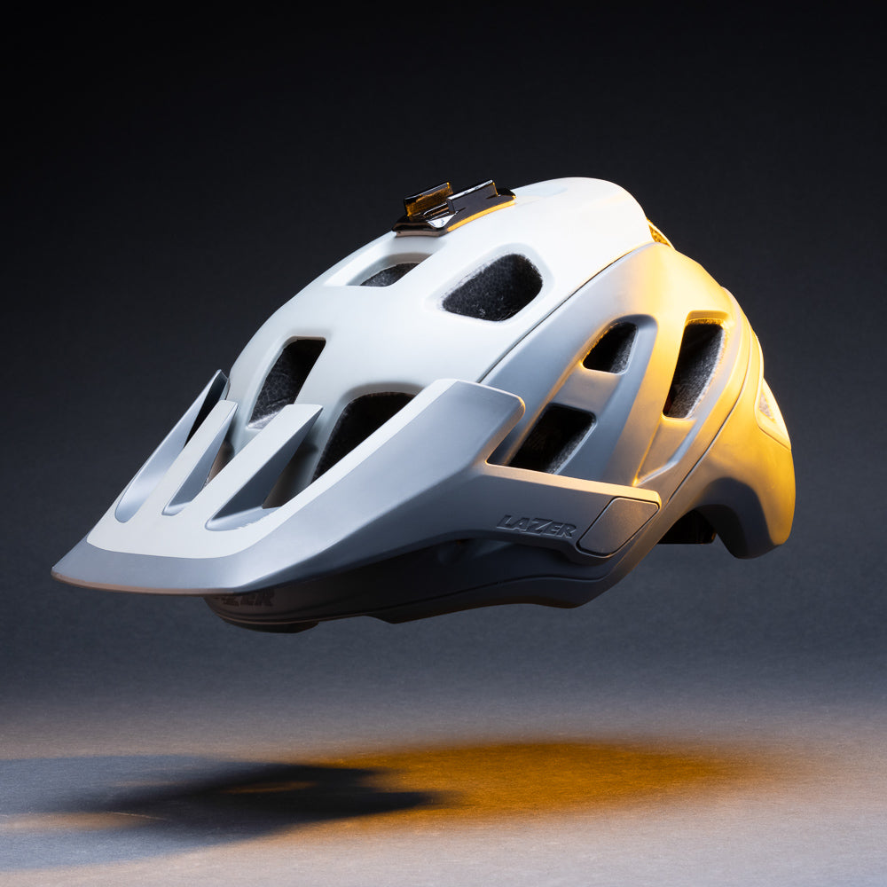 White mountain bike helmet with the curved helmet mount base attached, side view