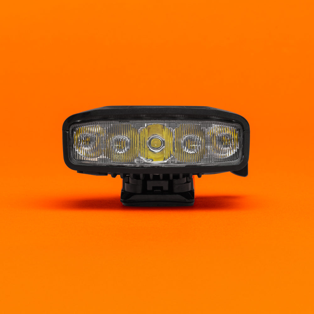 Portal bike helmet light straight-on front view of the LED optics, on an orange background