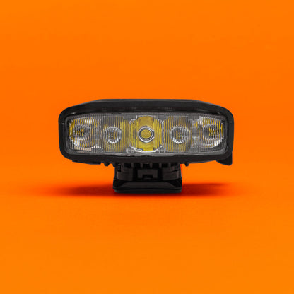 Portal bike helmet light straight-on front view of the LED optics, on an orange background