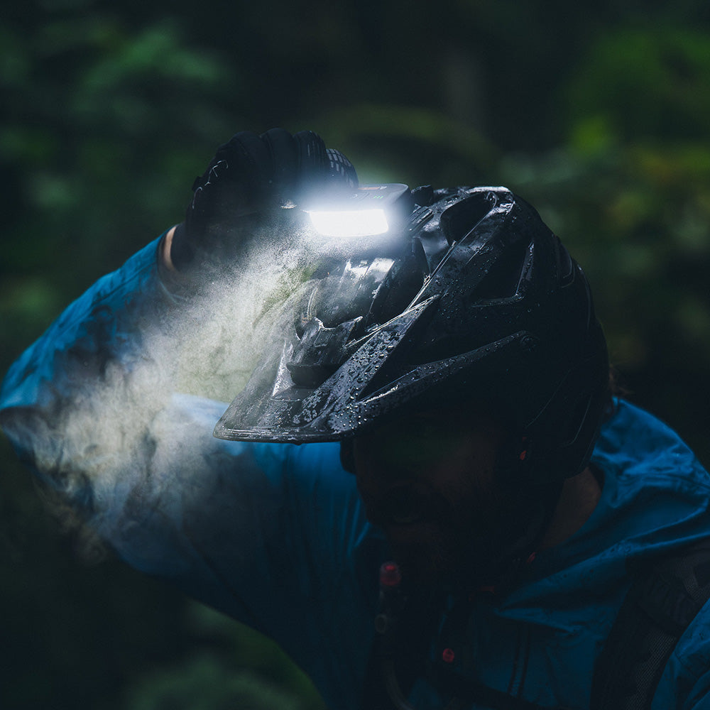 Portal bike helmet light shining through mist from a rider's helmet on a night ride