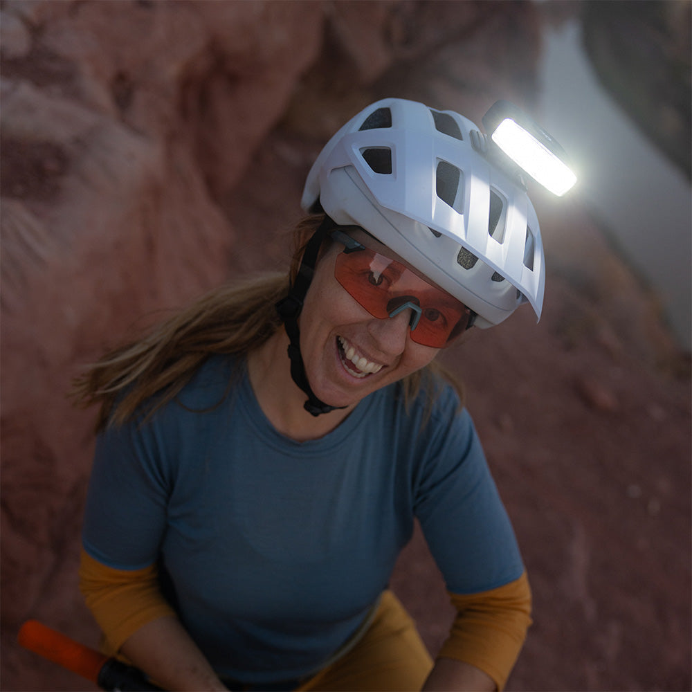 Smiling rider wearing a white helmet with the Portal bike helmet light switched on