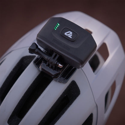 Portal bike helmet light on a white helmet, seen from behind, with green battery indicator lights and the action camera style mount