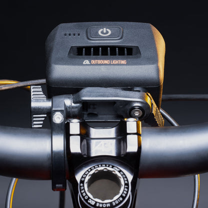 Bike light on the quick release handlebar mount clamped beside the stem, rider's view